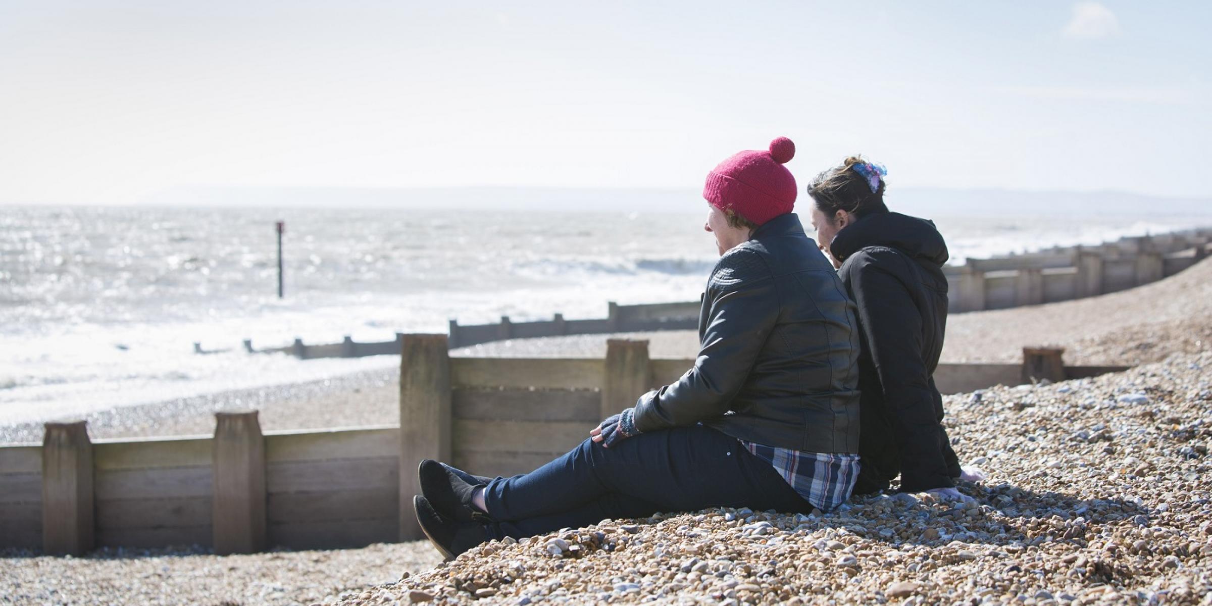 Two people sitting on the beach