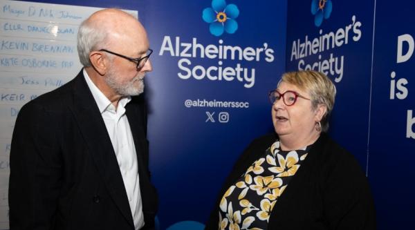 Michelle talking to someone with an Alzheimer's society backdrop